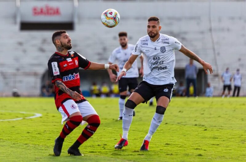 Jogador do Campinense prestes a dominar a bola no peito ou de cabeça, e adversário de camisa branca marcando, simbolizando os melhores confrontos entre Treze e Campinense